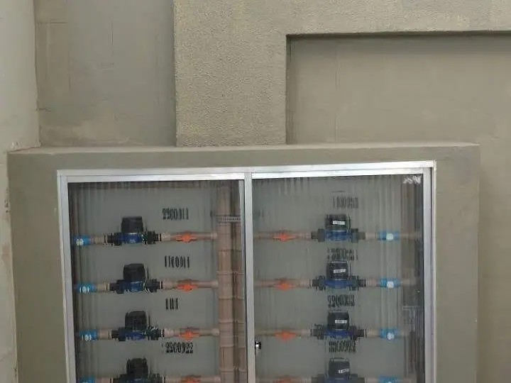 Abrigo de hidrômetros com porta de vidro instalado na parede de um condomínio