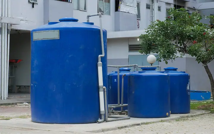 Caixas d’água azuis ao lado de um prédio residencial